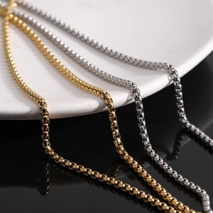 Polished gold and silver stainless steel 26mm cross necklaces on elegant display