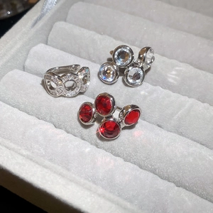 Detailed view of silver zircon hollow ear cuffs with red and clear crystal accents