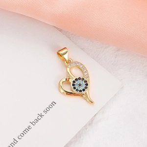 Macro shot of gold-plated heart pendant with evil eye motif and clear cubic zirconia