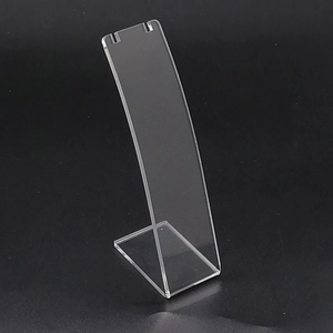 Close-up of a clear acrylic necklace stand with dual top slots on a dark background