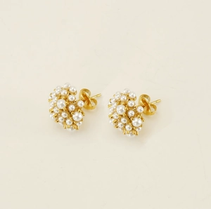 Detail view of gold clustered pearl stud earrings with secure butterfly backings