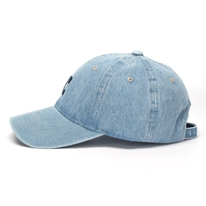 Detail view of light blue denim baseball cap featuring navy blue NY embroidered logo
