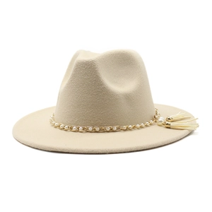 Detail of wool fedora hat with gold pearl chain and fringe tassel in beige color