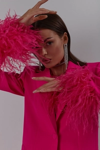 Detail of rose red blazer with ostrich feather cuffs and silver tassel earrings