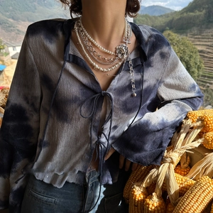 Detail of layered necklace with white pearls, silver chains and a lion head pendant