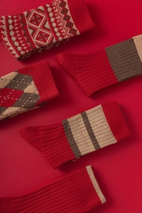 Chaussettes en laine épaisses avec motifs Fair Isle et flocons sur un fond rouge vif