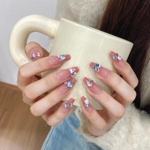 Detail of pink jelly press-on nails with star rhinestones and long coffin shape