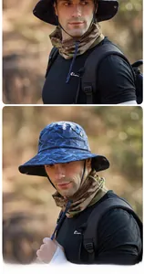 Modello maschile con cappello da pescatore mimetico e scaldacollo per esterni