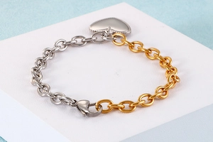 Detailed shot of two-tone gold and silver heart bracelet with secure lobster clasp on stand