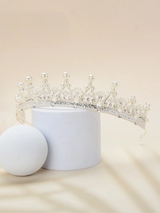Detailed macro of a silver bridal tiara featuring elegant white pearls and rhinestones
