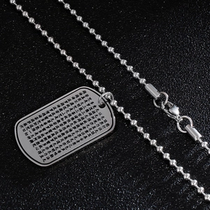 Macro detail of silver titanium steel military tag necklace with engraved lotus sutra