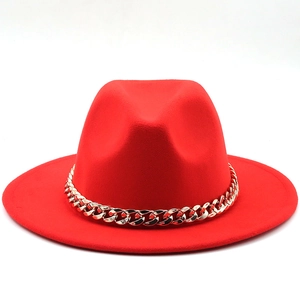 Detail of red wool felt fedora featuring a bold gold metal chain accent and wide brim