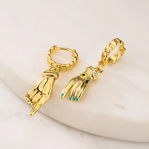Detail of gold-plated palm charms with turquoise enamel and CZ on marble base