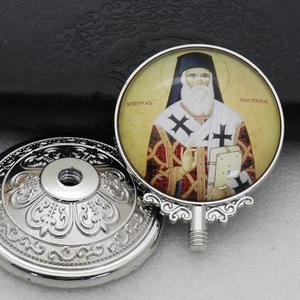 Detailed macro view of silver metal Saint Nectarie icon with a threaded screw-in base