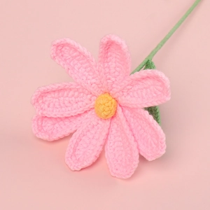 Macro shot of handmade crochet cosmos flower with pink petals and green stem detail