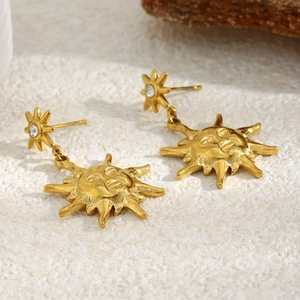 Détail macro de la boucle d'oreille soleil vintage en acier inoxydable doré 18 carats