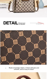 Detail of monogram PU leather handbag featuring golden heart charm and refined texture