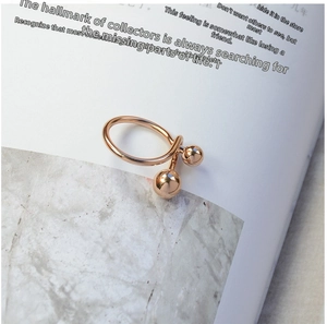 Detail of rose gold double ball open ring on a magazine lifestyle background