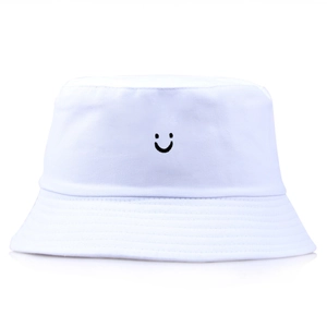 Minimalist white cotton bucket hat with a black embroidered smiley face on a plain background