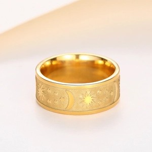 Macro shot of gold sun moon star ring featuring embossed patterns and sandblasted finish