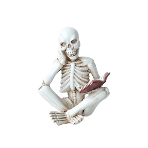 Creative skeleton figurine sitting and reading a red book for Halloween home decor