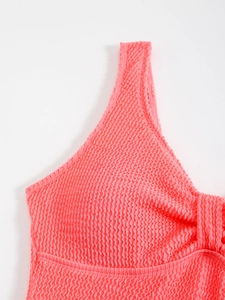 Vue détaillée de la texture du tissu seersucker rose corail et du nœud plissé