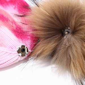 Tie-dye knit beanie featuring a detachable faux fur pompom with metal snap button