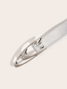 Detail of silver faux leather belt featuring a unique rhinestone-encrusted metal buckle