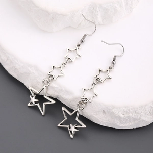 Détail des boucles d'oreilles étoiles argentées avec triple design de pentagramme