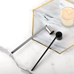 Silver and black stainless steel candle snuffers with long handles on marble tray