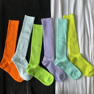Detailed flat lay of six colorful ribbed cotton blend mid-calf socks in vibrant shades