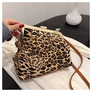 Detail of leopard print shell bag with golden metal clasp and brown slim strap