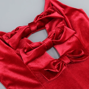 Détail d'une robe en velours rouge avec trois nœuds évidés et une texture élégante
