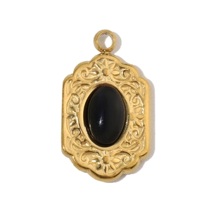 Detailed view of an oval black agate stone set in a vintage carved gold steel pendant