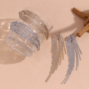 Detail of elegant gold and silver long tassel fringe earrings with shimmering cubic zirconia