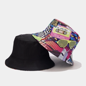 Close-up of double-sided bucket hats with 80s graffiti prints and solid black cotton fabric