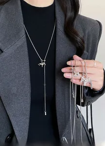 Macro detail of silver horse pendant necklace with adjustable tassel chain