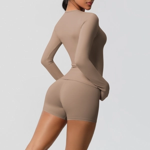 Side view of woman in mocha brown long sleeve yoga top and high waist shorts