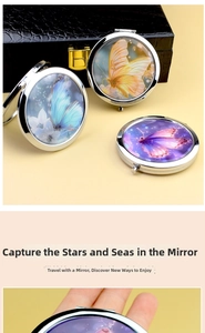 Detail view of round folding makeup mirror featuring artistic butterfly patterns and silver frame