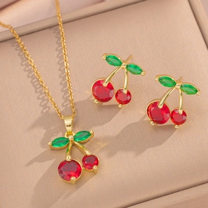 Golden necklace and earrings set featuring cherry motifs with red and green gemstones