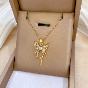 Macro del ciondolo a farfalla dorata con cristalli scintillanti in una confezione regalo