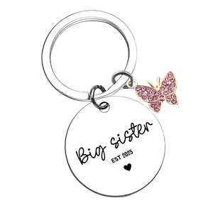 Détail macro du porte-clés Big Sister 2025 en acier avec pendentif papillon rose