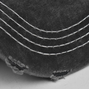 Macro detail of parallel white stitching and distressed edge on washed cotton cap