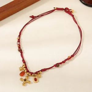 Red braided cord necklace with carnelian beads and golden cross pendant in ethnic style
