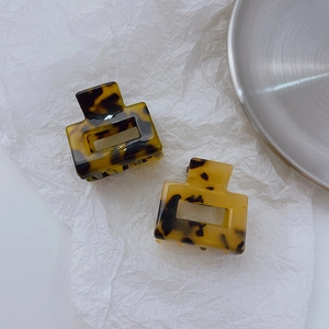 Set of two tortoise shell acetate hair claws in hollow square design on white paper