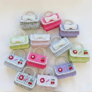 Close-up of children tweed handbags with pearl handles and decorative bow details