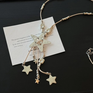Bohemian silver star pendant necklace with beige woven rope and vintage tassel detail