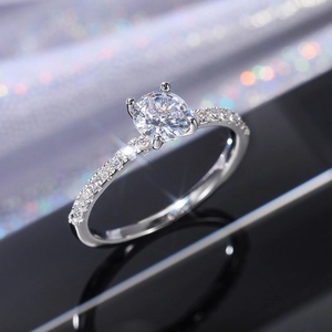 Macro shot of a four-prong round zircon ring with a sparkling pavé diamond-set band