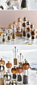 Macro shot of manual pepper grinders with clear acrylic bodies and diverse wooden knobs