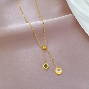 Detail of gold Y-necklace with Roman numeral pendants and adjustable sliding bead